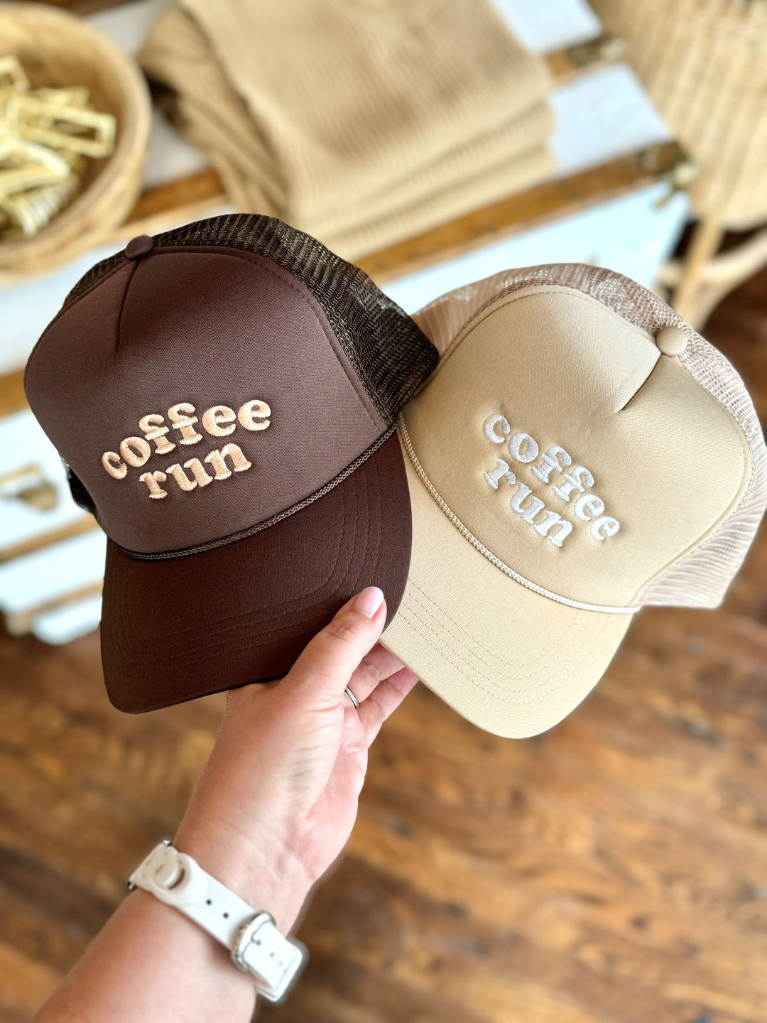 A brown and beige trucker hat with the words "coffee run" displayed prominently on the front in a coordinating tan color, showcasing a casual and chic style. Perfect for everyday wear and adding a trendy touch to your coffee runs. Available at Maven Blush Boutique.