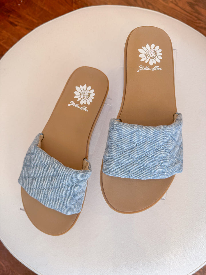 Sanibel Denim Slide Sandal with puffy quilted straps and a cushioned footbed, designed for effortless everyday wear. Light denim color.