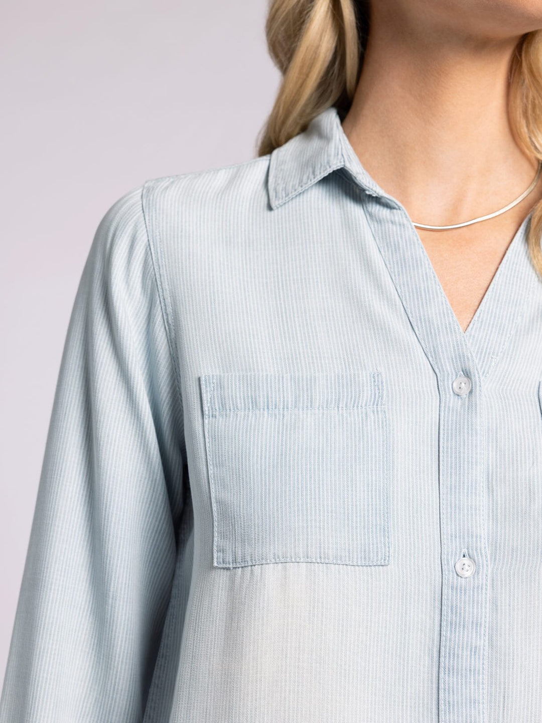 Close-up view of the Ginger Mia Pinstripe Top by Thread and Supply in soft Tencel with a relaxed fit, button-front closure, and dual front pockets, styled for effortless layering.