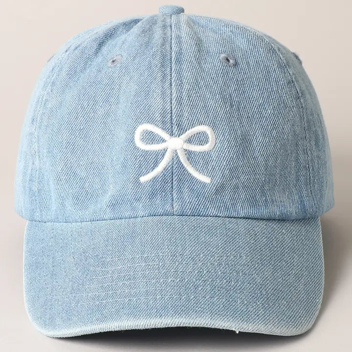 Light blue denim hat with embroidered bow and adjustable strap.