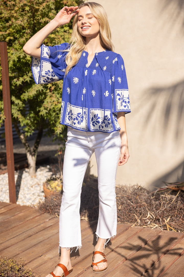 Royal blue smocked floral top with short sleeves and block print design, styled for everyday or office wear. Brand Voy.