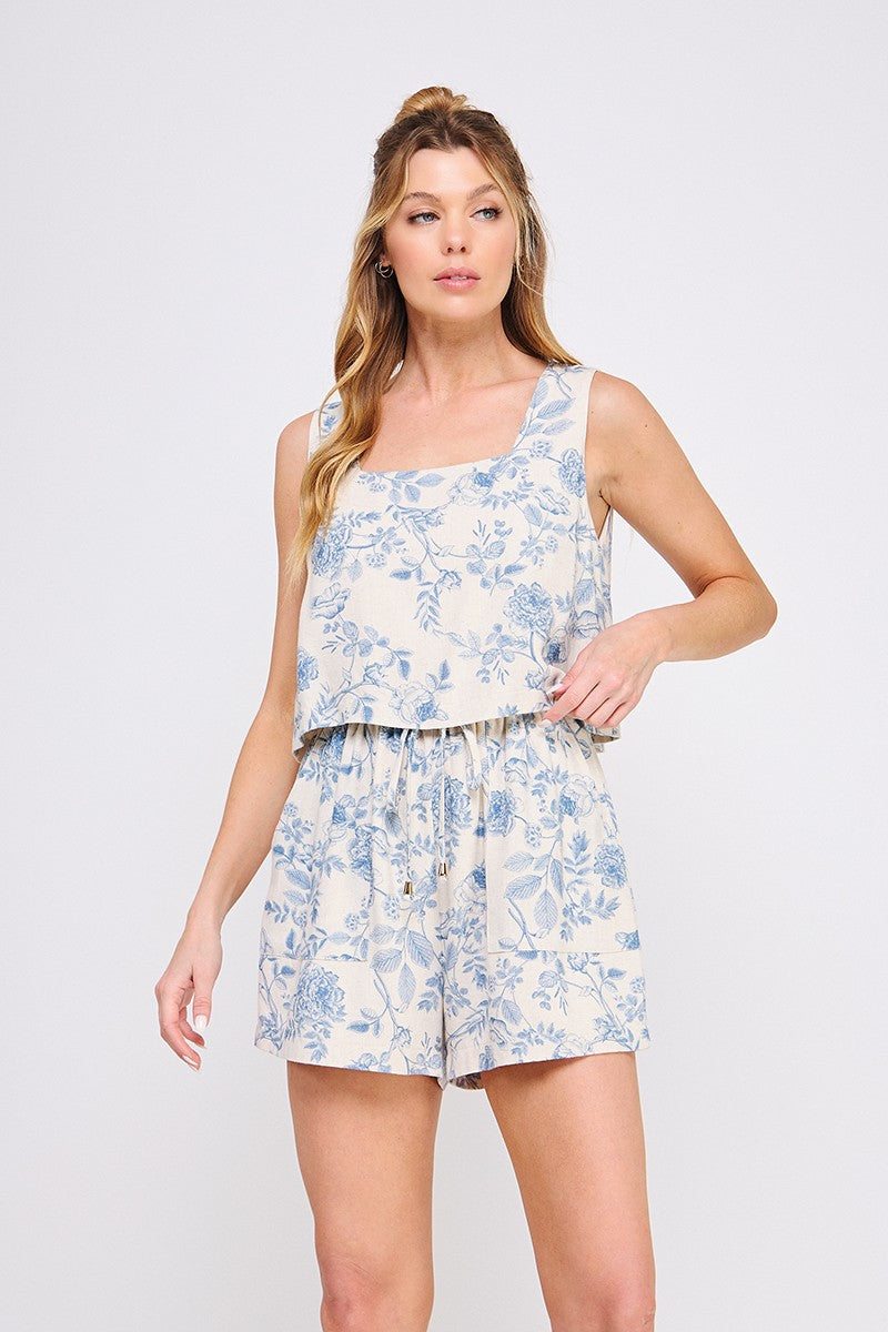 Nia linen short romper in blue and cream toile print with square neckline, faux tie waist, and overlay detail.