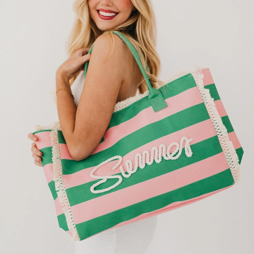 Oversized pink and green striped summer beach tote with rope lettering and fringe.